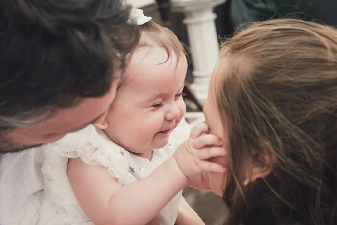 Bebê no colo da mãe, olhando para a câmera